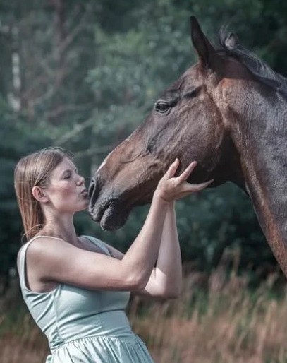 Vendula giving a bay horse a kiss on the nose